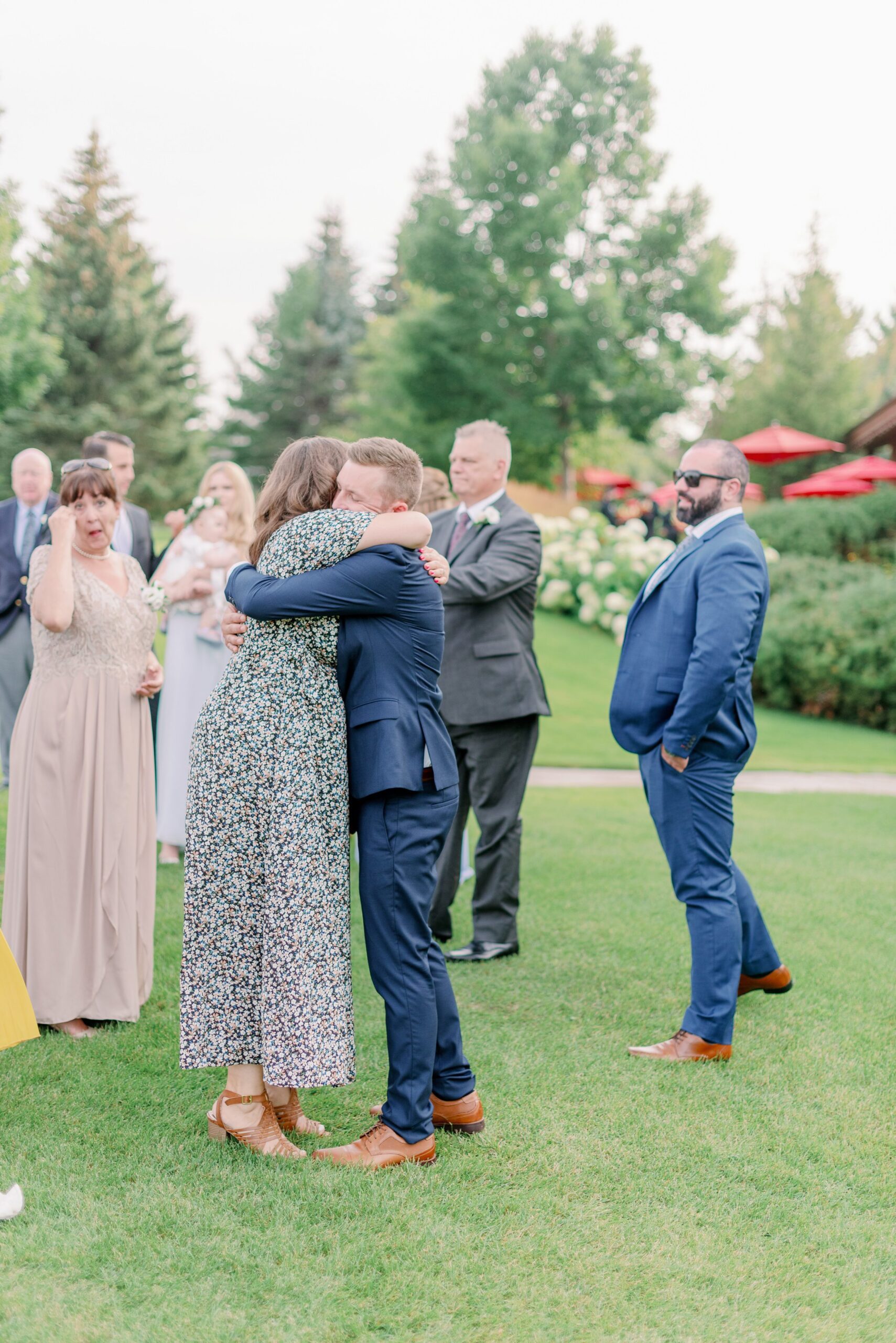 Candid moment of guests hugging at Barrie wedding.