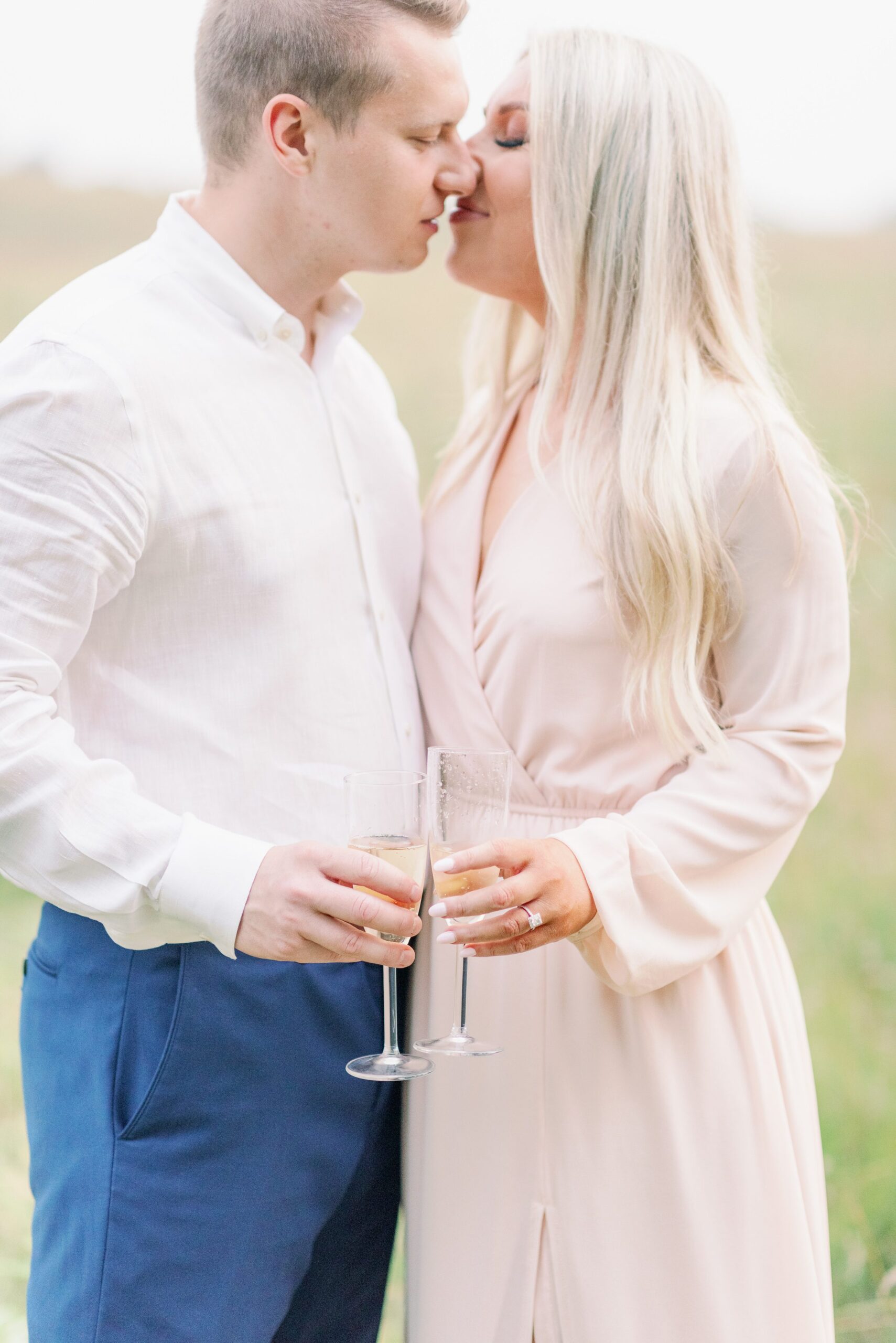 Bride and groom almost kissing while holding champagne