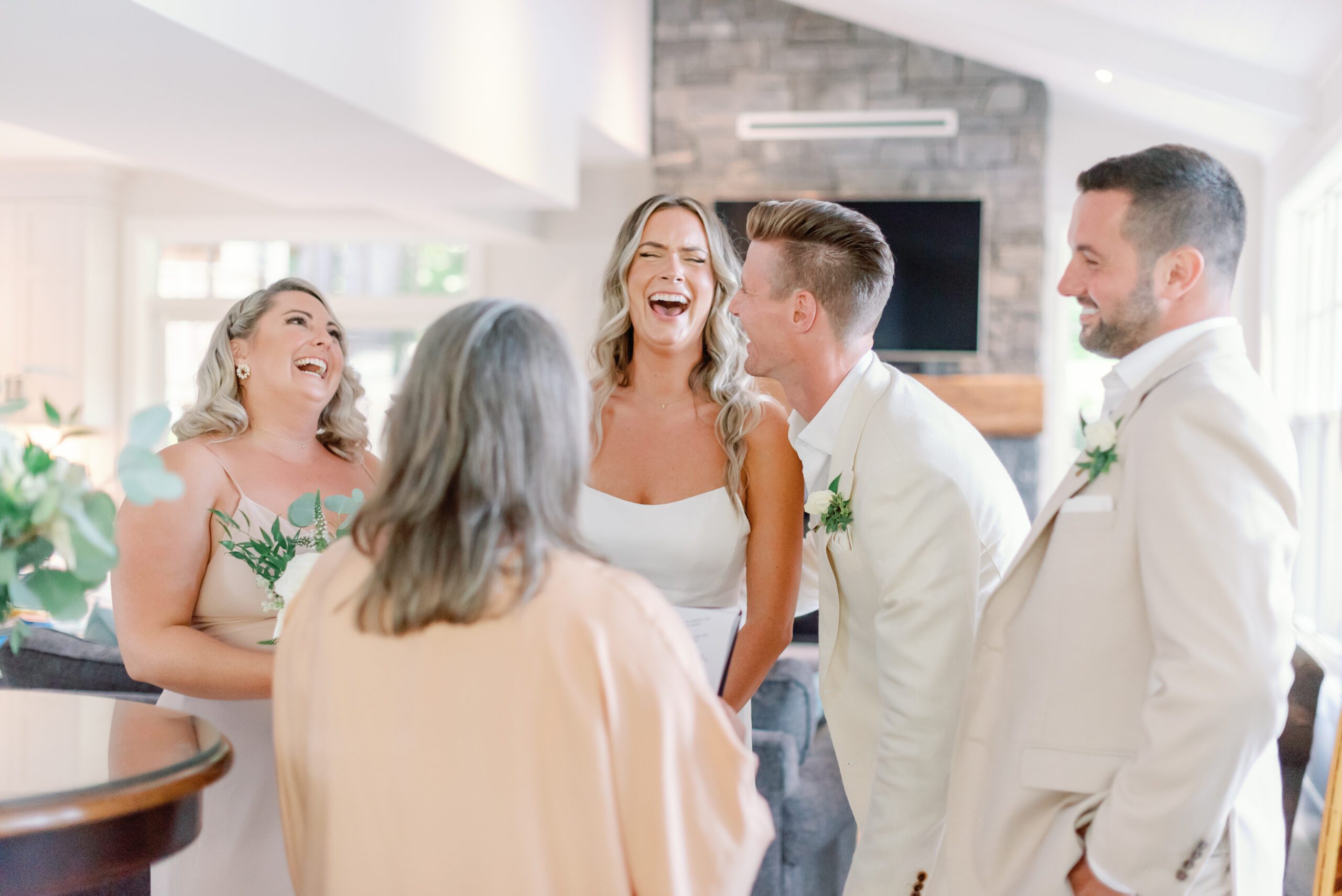 Wedding couple laughing with guests.