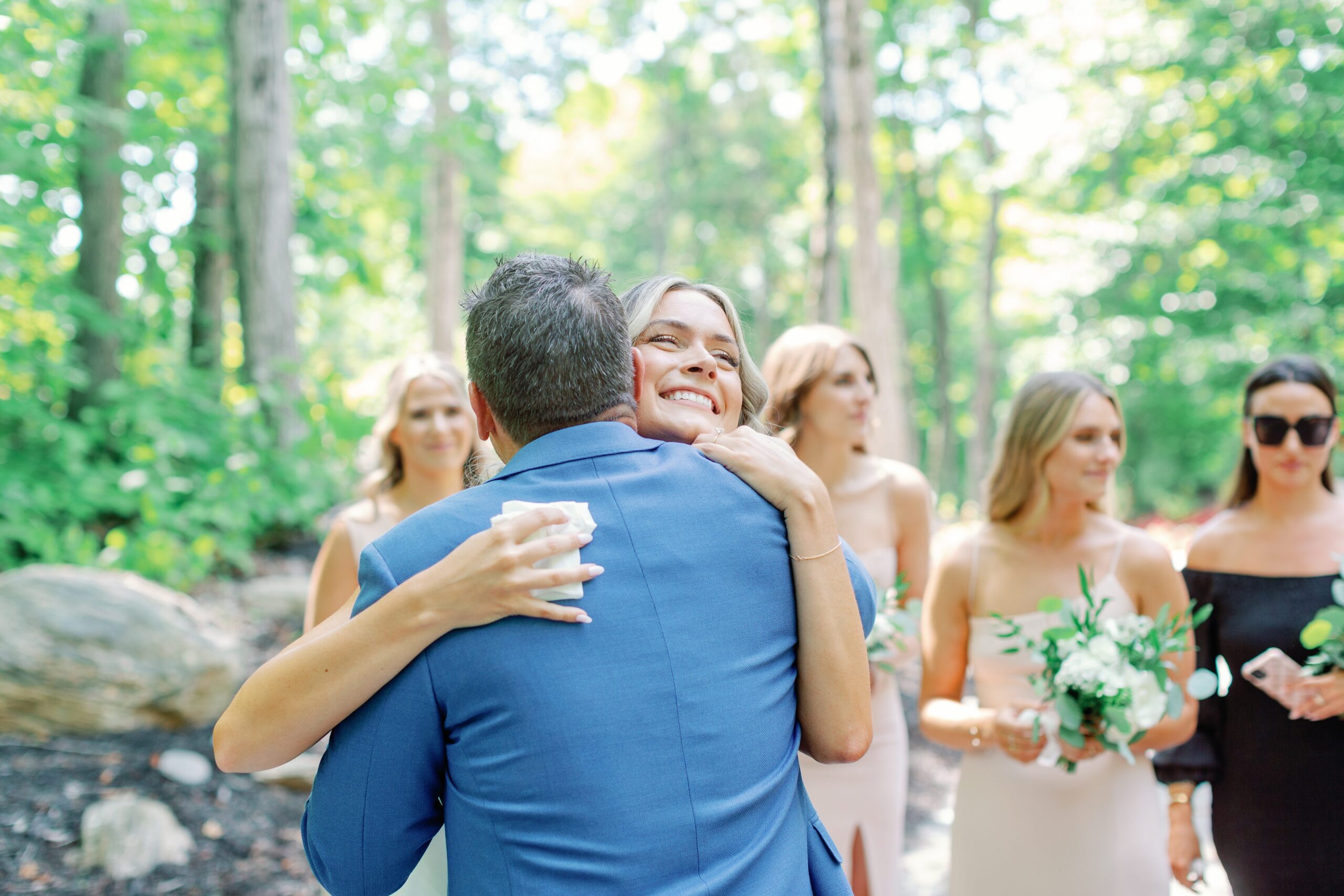 Candid moment of people hugging at outdoor wedding. Photographed by Maranda Elysse Photography.