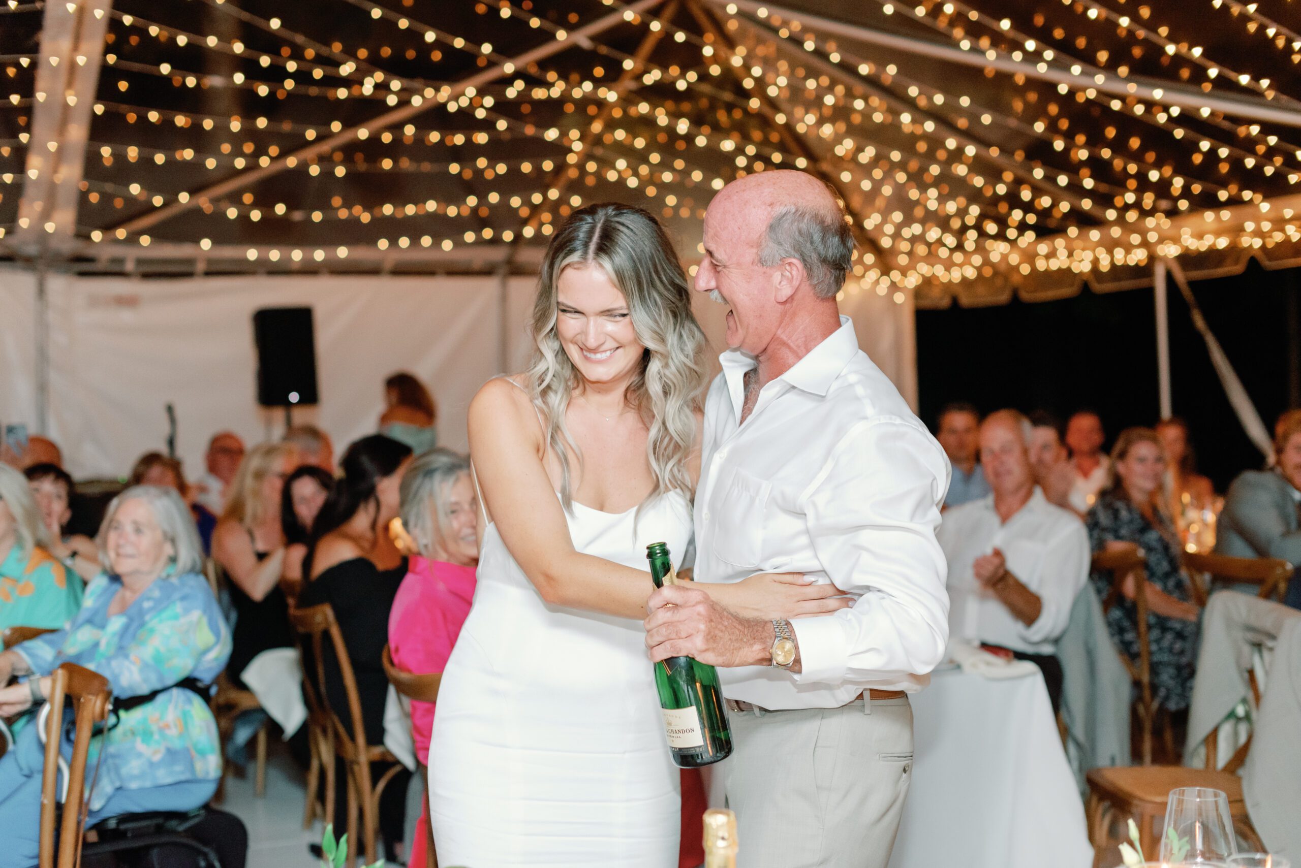 Bride and father laughing at wedding reception.